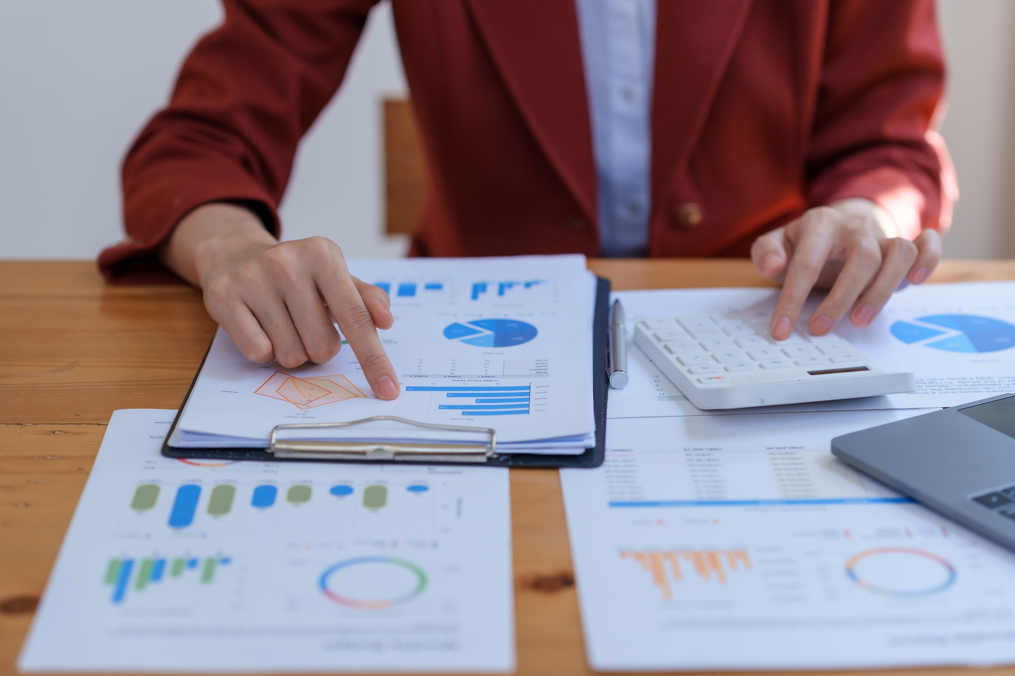 Business woman consultant pointing to graphs and analyzing financial report